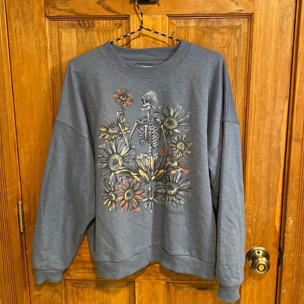 Blue pullover sweatshirt with skeleton and flowers from American Eagle.